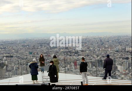 Tourist enjoying the views from the Shibuya Sky rooftop observation deck on top of the Scramble Square building in Shibuya, Tokyo, Japan. Stock Photo