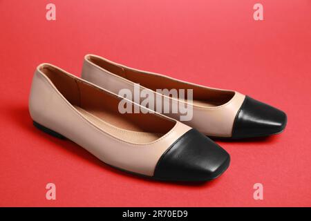 Pair of new stylish square toe ballet flats on red background Stock Photo