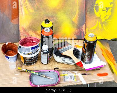 Samara, Russia - May 27, 2023: Different used cans of spray paint and paint brushes for creative Stock Photo