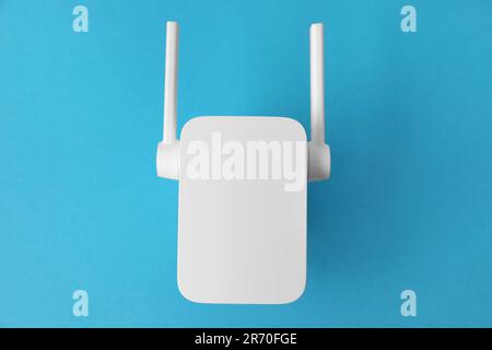 New modern Wi-Fi repeater on blue background, top view Stock Photo