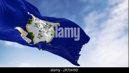 Close-up view of the Connecticut state flag fluttering. White shield on blue background featuring three grapevines each bearing bunches of grapes. 3d Stock Photo