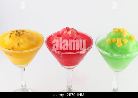 Three delightful martini glasses filled with different colored cocktails, all frosted with condensation isolated on a white background Stock Photo