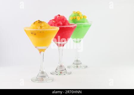 Three delightful martini glasses filled with different colored cocktails, all frosted with condensation isolated on a white background Stock Photo