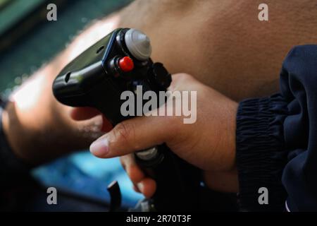 A young man holding a red-buttoned game controller in his hands Stock Photo