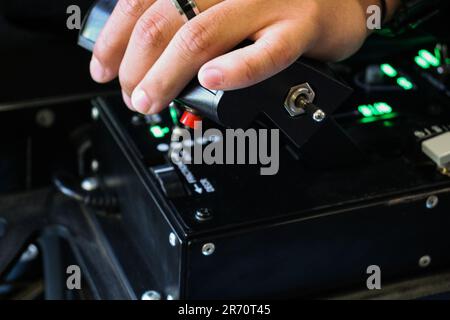 A young man holding a red-buttoned game controller in his hands Stock Photo