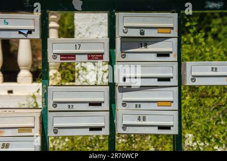 various colored mailboxes along the side of the road Stock Photo