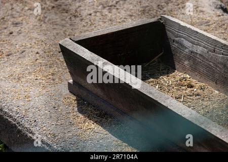 Wooden trough in the park for feeding herbivores, an old wooden trough with food for animals and birds Stock Photo