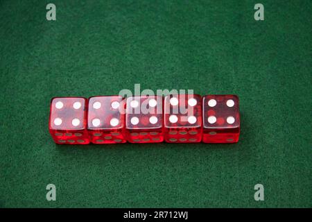Red Dice on a green baize tabletop Stock Photo