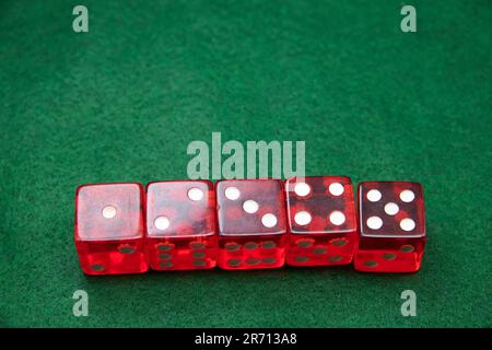 Red Dice on a green baize tabletop Stock Photo