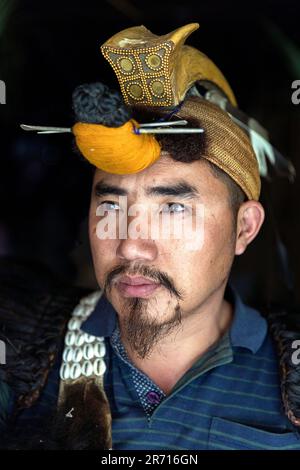 Portrait of a young Nishi man wearing traditional head-dress including the beak of the Hornbill bird, Arunachal pradesh, Northeastern India Stock Photo