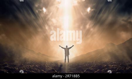 Man with arms to the sky illuminated by a beam of heavenly light Stock Photo