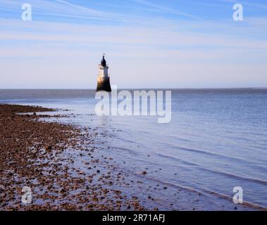 Gentle waves lead the eye to Plover Scar Lighthouse on Cockerham beach, near Lancaster Stock Photo