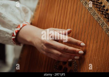 Woman playing on ethnic traditional ukrainian instrument bandura or pandora Stock Photo