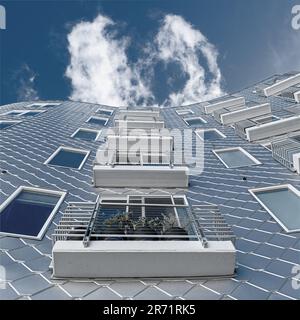 Curved modern architecture on an apartment building under a bright blue sky Stock Photo