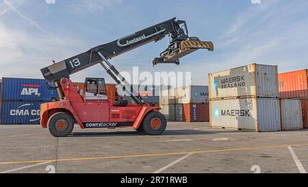 Dobanovci, Serbia - March 3, 2017: Reach Stacker Lifting Shipping Container at Cargo Terminal. Stock Photo