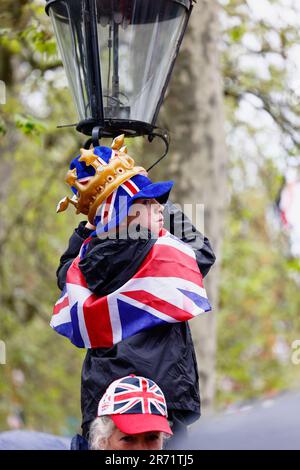 England, London, The Mall,  Young boy climbing lamp post to get better view of the coronation of King Charles III on a rainy May 6th 2023. Stock Photo