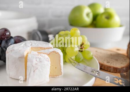 Soft Cheese or brie and grapes on a white plate with bread Stock Photo