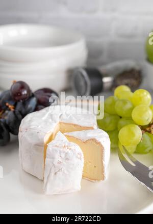 Soft Cheese or brie and grapes on a white plate with bread Stock Photo