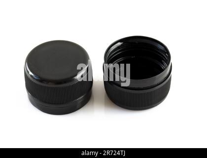 Two new black plastic caps on a white background. High dense plastic caps for plastic bottles. Circle screw lid for drink containers. Waste recycling Stock Photo