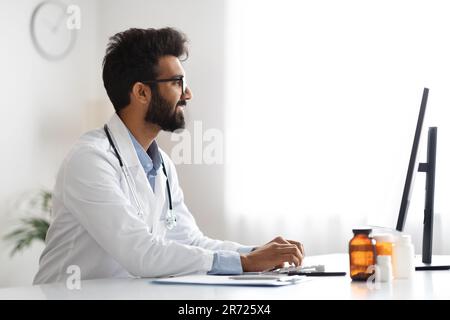 Handsome middle eastern young doctor working at clinic Stock Photo
