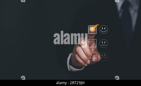 Satisfaction and Customer service concept ,Business man are touching the virtual screen on the happy Smiley face icon to give satisfaction in service. Stock Photo