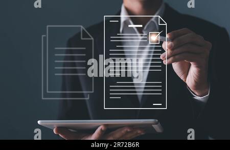 A businessman using a pen signing electronic documents on digital documents on a virtual screen Stock Photo