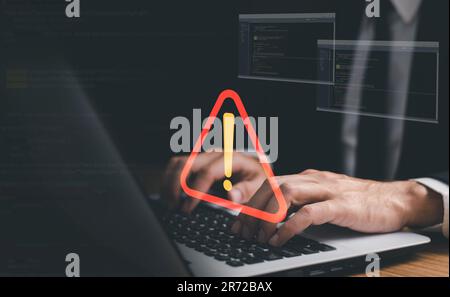 Businessman or it staff , programmer, developer using computer laptop with triangle caution warning sign for notification error and maintenance concep Stock Photo