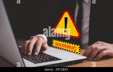 Businessman or it staff , programmer, developer using computer laptop with triangle caution warning sign for notification error and maintenance concep Stock Photo
