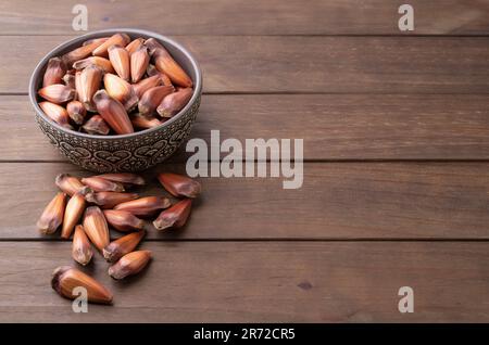 Pinions or pine tree seeds on a bowl over wooden table with copy space. Stock Photo