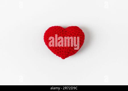 Crocheted red heart on a gray background. Symbol of love. Top view, flat lay Stock Photo