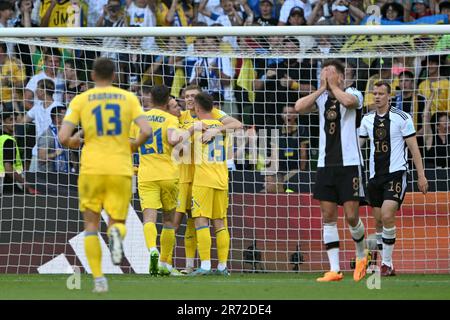 12 June 2023, Bremen: Soccer: International match, Germany - Ukraine, at wohninvest Weserstadion. Viktor Tsygankov (M, #15) from Ukraine celebrates with his teammates next to Germany's Leon Goretzka (2nd from right) and Germany's Lukas Klostermann (right) after scoring the 1:3 goal. IMPORTANT NOTE: In accordance with the regulations of the DFL Deutsche Fußball Liga and the DFB Deutscher Fußball-Bund, it is prohibited to use or have used photographs taken in the stadium and/or of the match in the form of sequence pictures and/or video-like photo series. Photo: Federico Gambarini/dpa Stock Photo