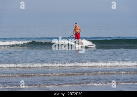 man on a paddle board in the surf Stock Photo