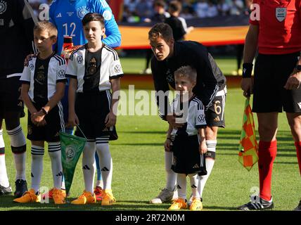 12 June 2023, Bremen: Soccer: internationals, Germany - Ukraine, at wohninvest Weserstadion. DFB captain Joshua Kimmich (center) stands with his own child next to the other children entering the stadium before the match. The German and Ukrainian national soccer teams walked onto the pitch at the Weserstadion together with 22 refugee children from Ukraine for the 1000th DFB international match in Bremen. The children fled Russia's attack on their homeland. IMPORTANT NOTE: In accordance with the requirements of the DFL Deutsche Fußball Liga and the DFB Deutscher Fußball-Bund, it is prohibited to Stock Photo