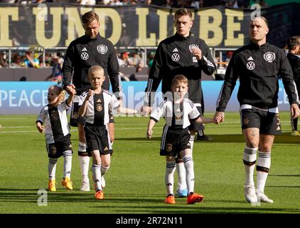 12 June 2023, Bremen: Soccer: internationals, Germany - Ukraine, at wohninvest Weserstadion. Germany's Niclas Füllkrug (l-r), Germany's Matthias Ginter and Germany's David Raum join the children on the pitch. The German and Ukrainian national soccer teams walked onto the pitch at the Weserstadion together with 22 refugee children from Ukraine for the 1000th DFB international match in Bremen. The children fled Russia's attack on their homeland. IMPORTANT NOTE: In accordance with the requirements of the DFL Deutsche Fußball Liga and the DFB Deutscher Fußball-Bund, it is prohibited to use or have Stock Photo