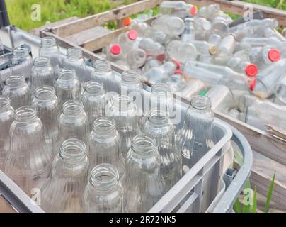 Used empty glass bottles stored in containers, selective focus. Stock Photo