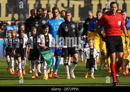 12 June 2023, Bremen: Soccer: internationals, Germany - Ukraine, at wohninvest Weserstadion. Germany's Joshua Kimmich (center) and his teammates join the children on the pitch. The German and Ukrainian national soccer teams walked onto the pitch at the Weserstadion together with 22 refugee children from Ukraine for the 1000th DFB international match in Bremen. The children fled Russia's attack on their homeland. IMPORTANT NOTE: In accordance with the requirements of the DFL Deutsche Fußball Liga and the DFB Deutscher Fußball-Bund, it is prohibited to use or have used photographs taken in the s Stock Photo