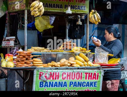 Hoi An, Vietnam, March 6th, 2023. A female street vendor selling Vietnamese snack food at Hoi An old town in a sunny day. Stock Photo