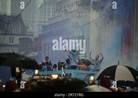 Manchester, UK. 12th June, 2023. Manchester City Football Club holds an open top bus victory parade celebration in central Manchester, UK, to mark the achievement of winning the treble: the Premier League, the FA Cup, and the Champions League. On Saturday Man City beat Inter Milan in Istanbul to secure the Champions League win. The parade of open top buses went through Manchester city centre watched by large, enthusiastic crowds, despite a thunderstorm and heavy rain. Credit: Terry Waller/Alamy Live News Stock Photo