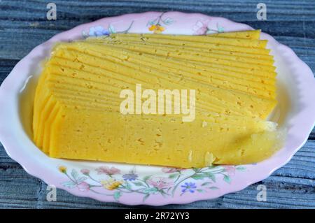 Slices of Egyptian Rumi cheese, also called gebna romiya or gebna turkiya, Roumi, Romi also Romy, middle Eastern parmesan hard cheese, has a pungent s Stock Photo