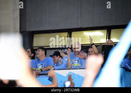 Manchester, UK. 12th June, 2023.  Pep Guardiola, manager of Man City, waves to fans from the top of the bus. Manchester City Football Club holds an open top bus victory parade celebration in central Manchester, UK, to mark the achievement of winning the treble: the Premier League, the FA Cup, and the Champions League. On Saturday Man City beat Inter Milan in Istanbul to secure the Champions League win. The parade of open top buses went through Manchester city centre watched by large, enthusiastic crowds, despite a thunderstorm and heavy rain. Credit: Terry Waller/Alamy Live News Stock Photo