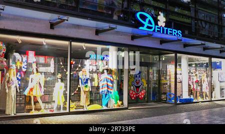 Nighttime photo of Deiters store front, a famous Cologne Germany landmark selling crazy costumes, many for the yearly Carnival festival held in February Stock Photo
