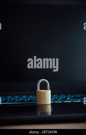 Golden padlock placed on black laptop computer in a conceptual image of cyber security and data protection. Stock Photo