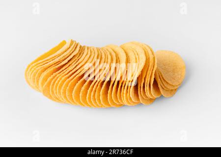 Potato chips of a beautiful identical shape on a white background close-up. Harmful food, snacks for beer. Stock Photo