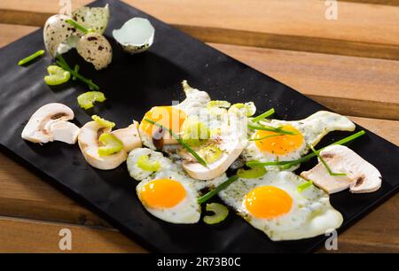 Fried quail eggs with champignons Stock Photo