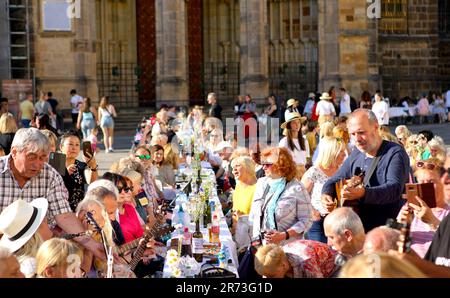 Prague, Czech Republic. 12th June, 2023. People take part in a long table event at Prague Castle in Prague, the Czech Republic, on June 12, 2023. A roughly 400-meter-long table in the shape of a heart was set up around St. Vitus Cathedral at Prague Castle on Monday. Prague's residents and visitors were welcomed to join the event with their own dishes and share with others. Credit: Dana Kesnerova/Xinhua/Alamy Live News Stock Photo