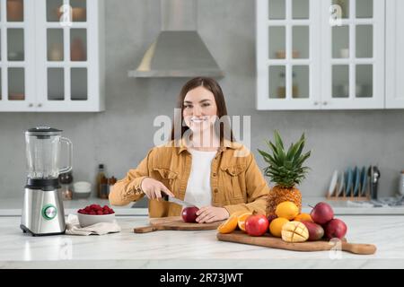 Woman preparing ingredients for tasty smoothie at white marble table in kitchen Stock Photo