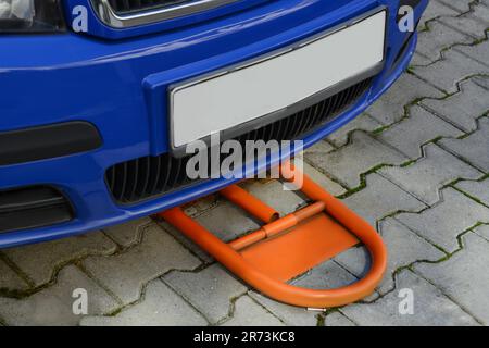 Parking barrier under car on pavement outdoors, closeup Stock Photo