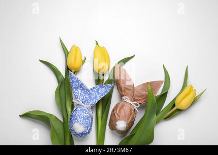 Flat lay composition with Easter bunnies made of paper and eggs on white background Stock Photo