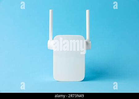 New modern Wi-Fi repeater on light blue background Stock Photo