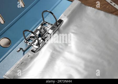 File folder with punched pockets on wooden table, closeup Stock Photo